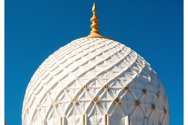 Intricate patterns on the presidential dome against a deep blue sky.